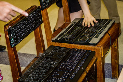 Midsection of woman touching computer keyboard on chair