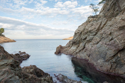 Scenic view of rock formation and sea against sky