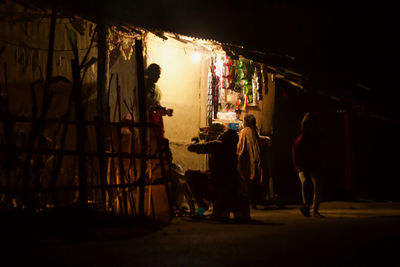 People standing on illuminated street at night