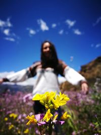 Young woman in front of yellow flowers