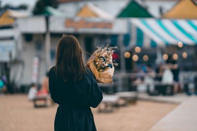 Woman holding ice cream standing outdoors