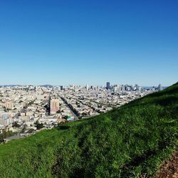 View of cityscape against clear blue sky