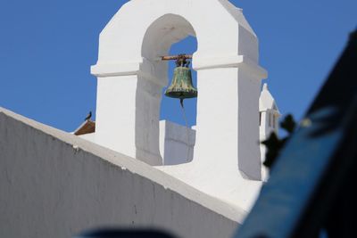 Low angle view of bell tower against blue sky