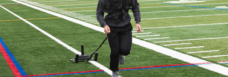 Low section of man standing on grassland