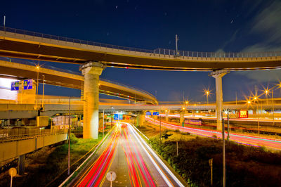 Light trails on road against sky at night