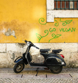 Bicycles parked on sidewalk against wall