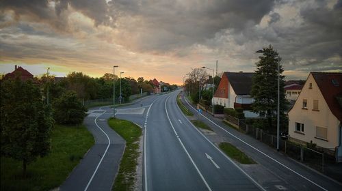 Road in town against sky during sunset