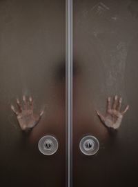 Person in bathroom seen through glass door