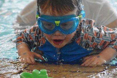 Portrait of cute boy swimming in sea