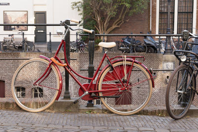 Bicycle leaning on railing against building