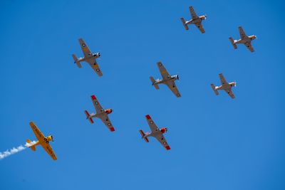 Low angle view of airplanes against clear blue sky