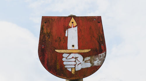 Low angle view of municipal coat of arms against sky