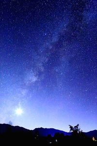 Low angle view of silhouette mountain against star field