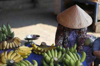 Street seller in hoi an vietnam. various fruits for sale at market stall