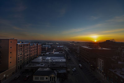 High angle view of street amidst buildings against sky during sunset