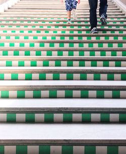 Low section of people walking on tiled floor