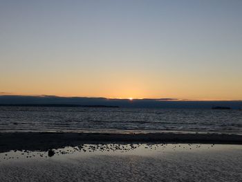 Scenic view of sea against clear sky during sunset