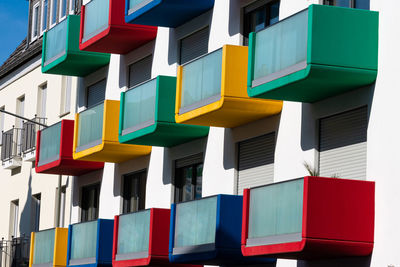 Facade of a residential building with multi colored vibrant balconies.