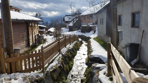 Snow covered houses amidst buildings in city