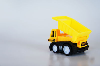 Close-up of yellow toy car over white background