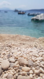 Close-up of pebbles on beach against sky