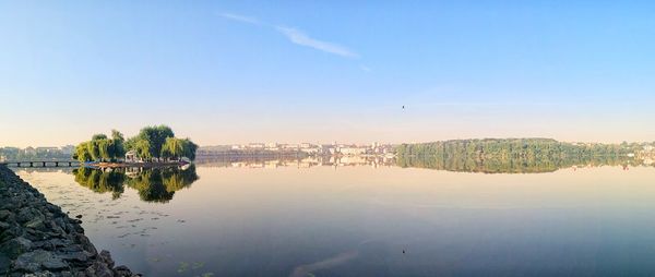 Scenic view of river against sky in city