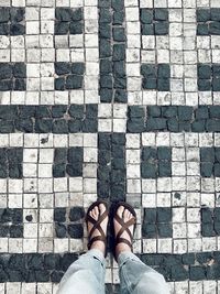 Low section of person standing on tiled floor