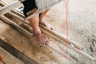 Low section of man working on loom