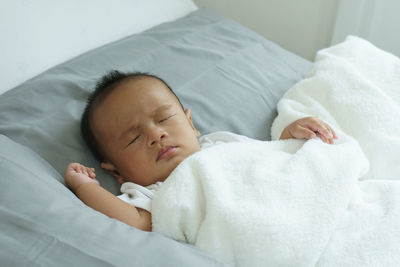 Cute baby boy sleeping on bed