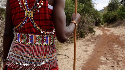 Rear view of maasai man standing on road