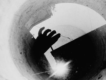 Shadow of woman hand with umbrella in water