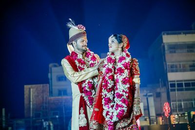 Happy bride and groom looking at each other during wedding ceremony at night