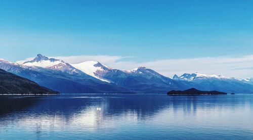 Scenic view of lake and snowcapped mountains against sky