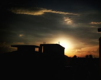 Silhouette buildings against sky during sunset