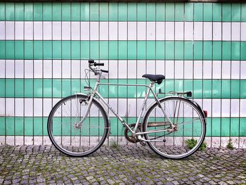 Bicycle on footpath against building