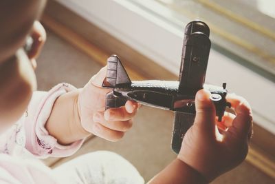 Close-up of baby playing with model airplane at home