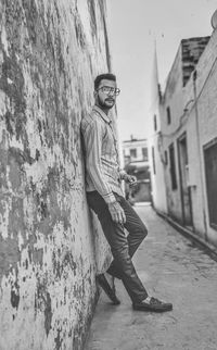 Portrait of young man standing against wall