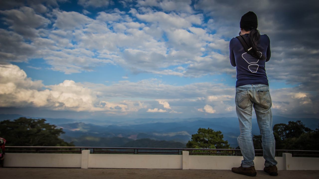 MAN STANDING ON ROAD AGAINST SKY