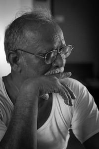Close-up of man wearing eyeglasses at home