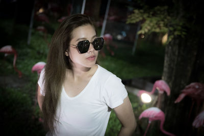 Portrait of young woman wearing sunglasses standing outdoors