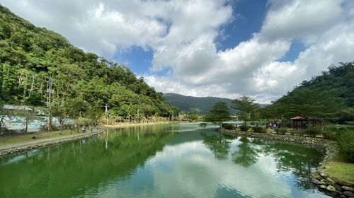 Scenic view of lake by trees against sky