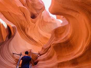 Rear view of man by rock formation
