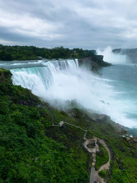 Scenic view of waterfall against sky