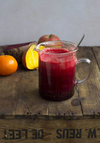 View of raw vegetable and fruit juice in measuring jug