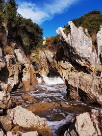 Rock formation amidst trees against sky