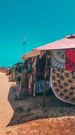 Clothes drying on beach against clear blue sky