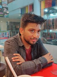 Portrait of young man sitting in restaurant