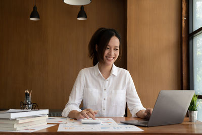 Portrait of young businesswoman working at desk in office