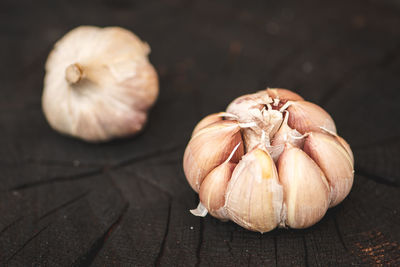 Garlic bulbs and cloves on a black wooden rustic board background, close up