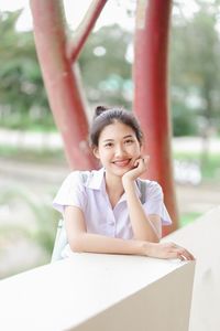 Portrait of a smiling young woman sitting on table